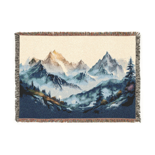 Woven blanket with mountain landscape design on a white background